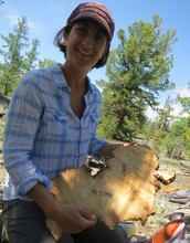 Scientist Amy Hessl holding a cross-section of wood from a preserved log.